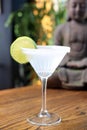 Margarita cocktail in a martini glass with salt rim, decorated with lime, selective focus, with blurred background. Royalty Free Stock Photo
