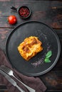 Classic meat lasagna with cheese Bechamel and Bolognese sauce, on plate, on old dark  wooden table background, top view, flat lay Royalty Free Stock Photo