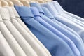 Classic men shirts made of cotton light cool tones on the clothes hanger in the store. Selling wear in blue color. Royalty Free Stock Photo