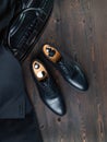 Classic men`s shoes on a wooden surface next to a portfolio of black crocodile leather and a jacket top view Royalty Free Stock Photo