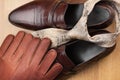 Classic mens brown shoes, tie, gloves, on wooden floor