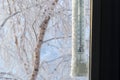 The classic mercury thermometer for outdoor temperature measurement hangs outside the window with readings of minus 35 degrees