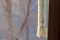 The classic mercury thermometer for outdoor temperature measurement hangs outside the window with readings of minus 35 degrees