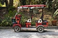 Classic modern red golf carts electric car stop on street road in garden park of Wat Samphran temple at Sam Phran city in Nakhon Royalty Free Stock Photo