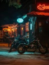 Classic motorcycles lined up outside a bustling bar with neon signs at night.