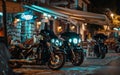 Classic motorcycles lined up outside a bustling bar with neon signs at night.