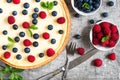 Classic New York cheesecake with fresh berries, mint and cutlery on stone background, top view Royalty Free Stock Photo