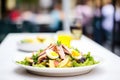 classic nicoise salad with a blurred restaurant background