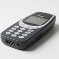 Classic Nokia 3310 Mobile Phone with USB Port and Headphone Jack on Light Gray Surface Royalty Free Stock Photo