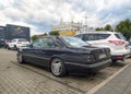 Classic old black coupe car Mercedes Benz 124 300 CE rear part and left side view parked