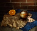 Classic Old Fashioned alcohol drink cocktail with ice ball and zest, orange, blue and brown craft paper and dry roses as
