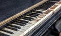 Classic old piano keys. The keyboard of a very old abandoned piano is covered with dust, some keys have dropped, some are absent