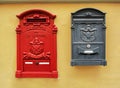 Classic old red and black Italian postboxes on a yellow painted stucco wall