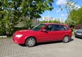 Classic old red Mazda 323 E hatchback private car parked