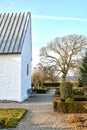 Classic old white farm house or church with a beautiful green garden in the yard. Home built with traditional Royalty Free Stock Photo