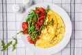 Classic omelet with cheese and tomatoes salad on white plate, top view Royalty Free Stock Photo