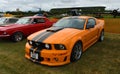 Classic Orange Ford Mustang S197 at airstrip.
