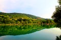 Classic panorama with Marche hilly landscape, emerald waters of the lake, tree silhouette and lush vegetation
