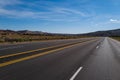 Classic panorama view of an endless straight road running through the barren scenery of the American Southwest.