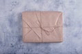 A classic parcel wrapped in kraft paper and tied with natural jute twine against a light concrete background. Royalty Free Stock Photo