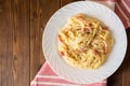 Classic pasta carbonara. Spaghetti with bacon, egg yolk and parmesan cheese on white plate on dark wooden background. Royalty Free Stock Photo