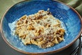 Classic pasta with wild mushrooms, cream sauce and parmesan in a blue plate on a wooden background. Close up, selective focus Royalty Free Stock Photo