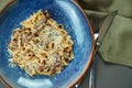 Classic pasta with wild mushrooms, cream sauce and parmesan in a blue plate on a wooden background. Top view, flat lay, copy space Royalty Free Stock Photo