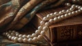 Classic pearls rest on an ornate, old-world book in a warm setting
