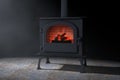 Classic ÃÅ¾pen Home Fireplace Stove with Chimney Pipe and Firewood Burning with Red Hot Flame in the Volumetric Light. 3d Rendering Royalty Free Stock Photo