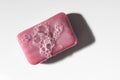 Classic pink bar of soap with bubbles shot from above top down on a clean white surface. Royalty Free Stock Photo