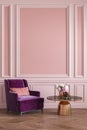 Classic pink interior with armchair, coffee table, flowes and wall moldings.