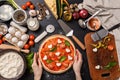 Classic pizza margherita with heart-shaped mazarella cheese. preparing a phased gala dinner for two at home in honor of Valentine