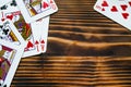 Classic playing cards on dark brown wooden table. Scattered cards.