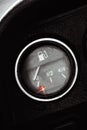 Classic pointer indicator of fuel level of the car. Low gasoline level with red alarm light lamp.
