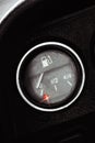 Classic pointer indicator of fuel level of the car. Low gasoline level with red alarm light lamp. Royalty Free Stock Photo