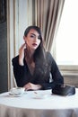 Classic poise. Portrait shot of an elegant young woman with coffee and a cigarette.