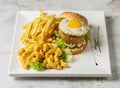 classic pork burger with sunny side up egg, mac and cheese and french fries served in dish isolated grey background top view Royalty Free Stock Photo