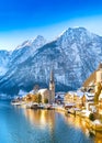 Classic postcard view of famous Hallstatt lakeside town in the Alps with traditional passenger ship on a beautiful cold sunny day Royalty Free Stock Photo