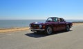 Classic Purple Triumph TR6 Sports Car being driven along Seafront Promenade.