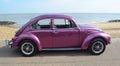 Classic Purple Volkswagen Beetle Motor Car Parked on Seafront Promenade.