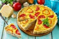 A classic quiche Lorraine pie with buckwheat, mushrooms, paprika, tomatoes, cheese and egg filling on a wooden table