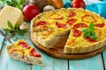 A classic quiche Lorraine pie with buckwheat, mushrooms, paprika, tomatoes, cheese and egg filling on a wooden table