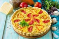 A classic quiche Lorraine pie with buckwheat, mushrooms, paprika, tomatoes, cheese and egg filling on a wooden table.