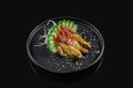 Classic raw eel sashimi with daicon raddish on a stylish black ceramic plate on a black background. Japanese traditional food.