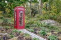 A Classic Red British Phone Booth in Lush Landscaping