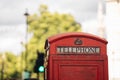 Classic red British telephone box in London with blurred background on hot sunny summer day Royalty Free Stock Photo