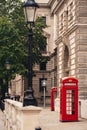 Classic red British telephone box in London with blurred background on hot sunny summer day