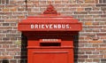 Classic red Dutch letterbox standing outside Royalty Free Stock Photo