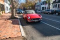 Classic red MG MGB Roadster from 1972 under fall trees on brick sidewalk Royalty Free Stock Photo