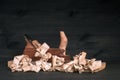 Classic red oak wood plane in a pile of fine wood shavings on a dark wooden background